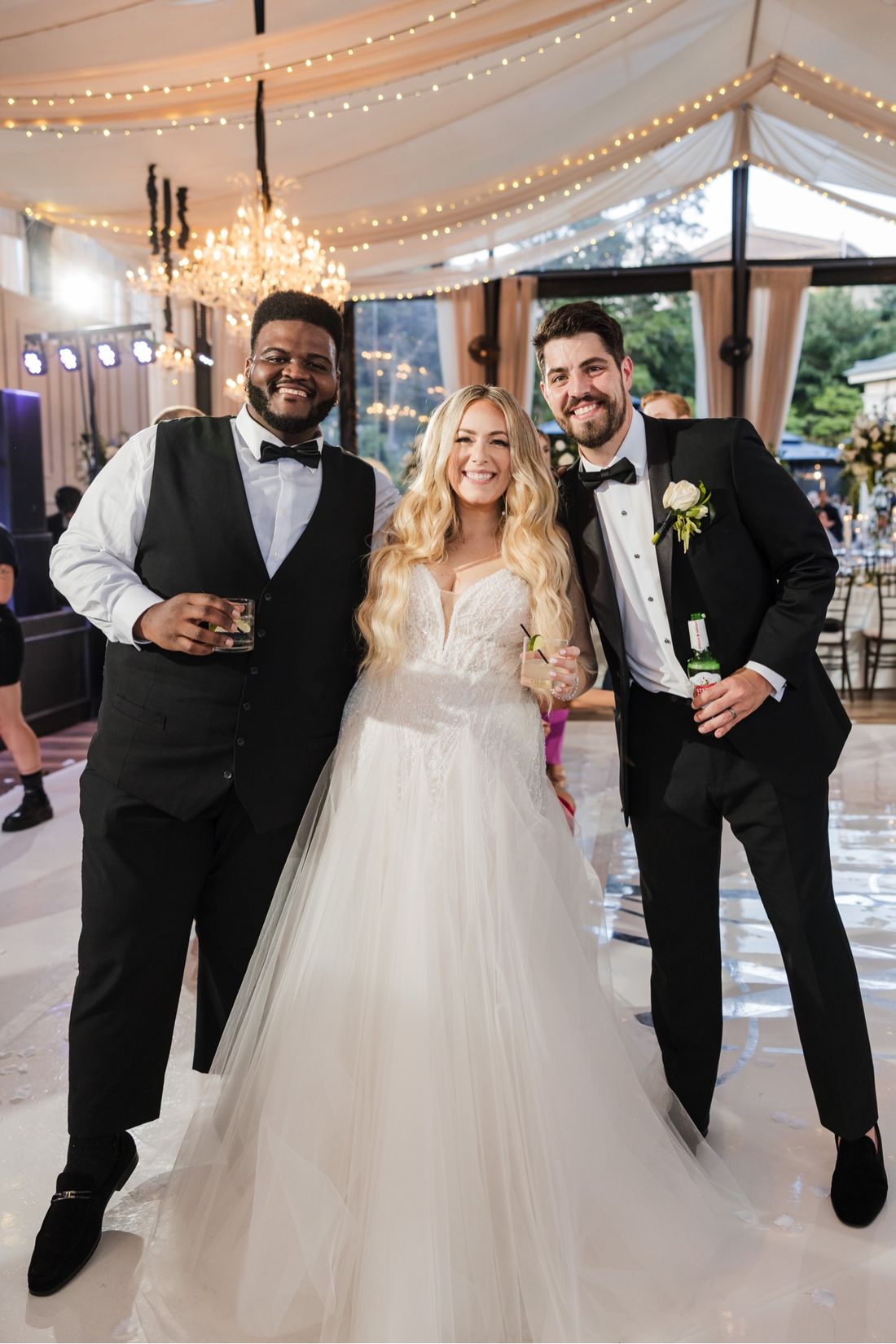 Tam celebrating with a bride and groom at their wedding reception
